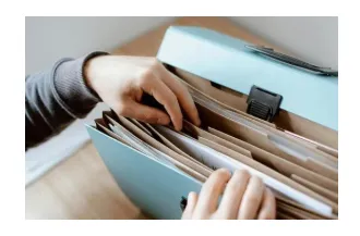 Hands pulling a document from a file folder