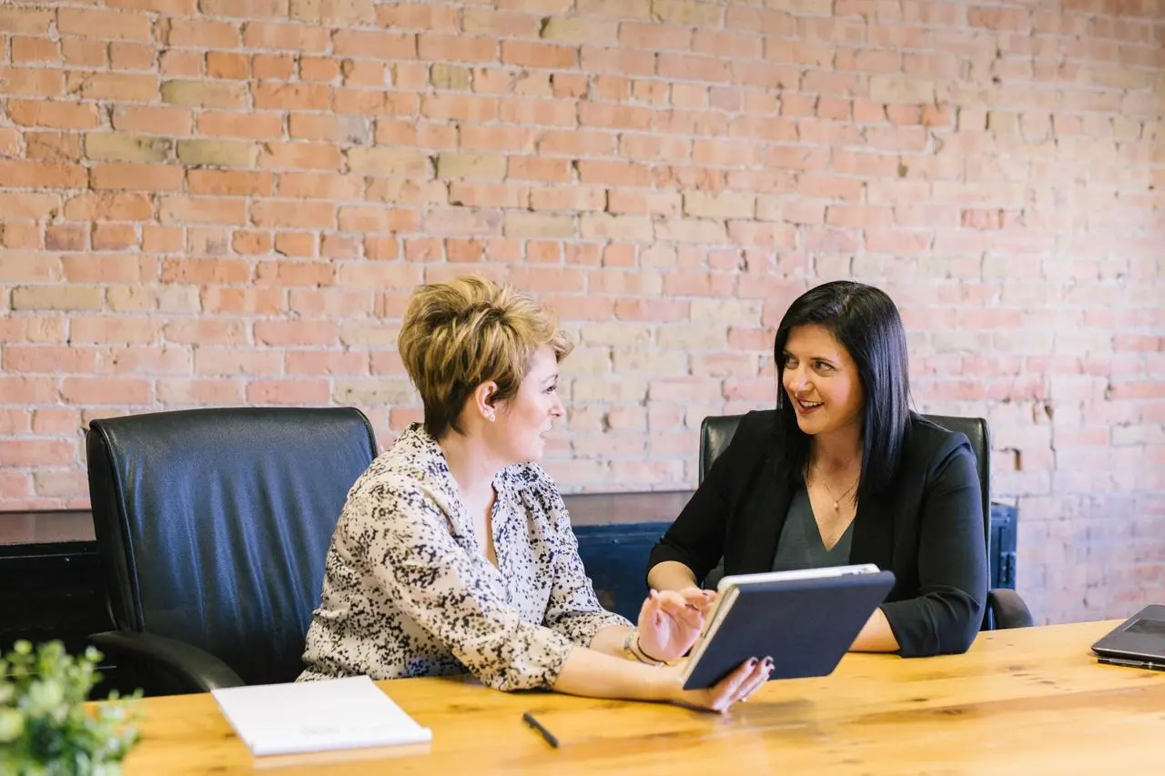 Two originators reviewing a file together at a conference table